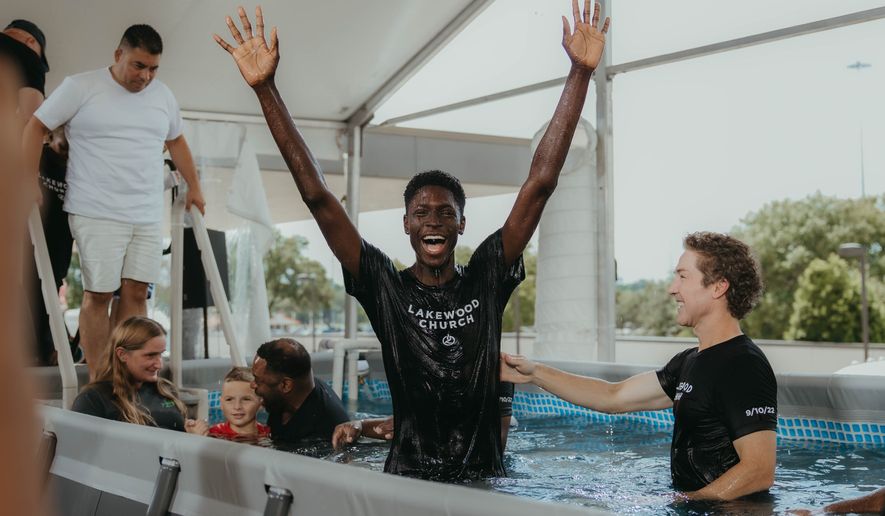 A believer exults after being baptized by Lakewood Church pastor Joel Osteen (right) on Sept. 10. The candidate was one of more than 1,000 people immersed by the televangelist in a four-hour ceremony. (Courtesy of Lakewood Church)