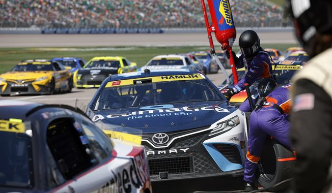 Denny Hamlin and other racers make a pit stop during a NASCAR Cup Series auto race at Kansas Speedway in Kansas City, Kan., Sunday, Sept. 11, 2022. (AP Photo/Colin E. Braley) **FILE**