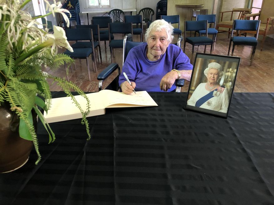 Pitcairn Island resident Royal Warren, age 94, signs a book of remembrance for the late Queen Elizabeth II in the island’s Public Hall. The volcanic outcropping in the middle of the Pacific Island is King Charles III&#39;s smallest outpost. (Photo by Melva Evans)