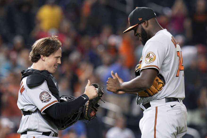 Baltimore Orioles catcher Adley Rutschman, left, and relief pitcher Felix Bautista celebrate the team&#39;s 4-3 win in a baseball game against the Washington Nationals at Nationals Park, Tuesday, Sept. 13, 2022, in Washington. (AP Photo/Jess Rapfogel)