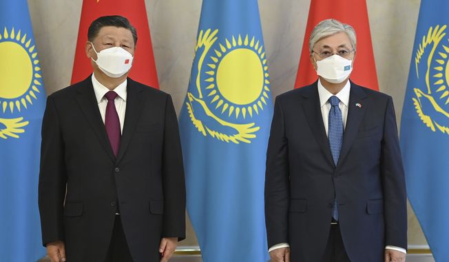 In this handout photo released by Kazakhstan President press-service, Kazakhstan President Kassym-Jomart Tokayev, left, and Chinese President Xi Jinping pose for photo during their meeting in Nur-Sultan, Kazakhstan, Wednesday, Sept. 14, 2022. (Kazakhstan President press-service via AP)