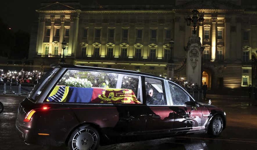 The hearse carrying the coffin of Queen Elizabeth II arrives at Buckingham Palace, London, Tuesday, Sept. 13, 2022, from where it will rest overnight in the Bow Room. (Paul Childs/Pool Photo via AP)