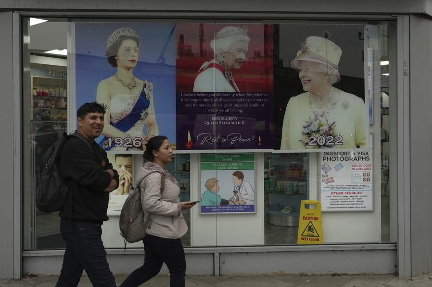 Posters of Queen Elizabeth II are displayed outside a pharmacy in the district of Southall in London, Tuesday, Sept. 13, 2022. In a church in a West London district known locally as Little India, a book of condolence for Queen Elizabeth II lies open. Five days after the monarch’s passing, few have signed their names. The congregation of 300 is made up largely of the South Asian diaspora, like the majority of the estimated 70,000 people living in the district of Southall, a community tucked away in London&#39;s outer reaches of London and built on waves of migration that span 100 years. (AP Photo/Kin Cheung)