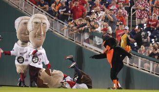 The Oriole Bird points at Teddy Roosevelt after pushing him to the ground in front of George Washington, left, and Thomas Jefferson while participating in the Presidents Race during the sixth inning of a baseball game at Nationals Park, Tuesday, Sept. 14, 2022, in Washington. (AP Photo/Jess Rapfogel)
