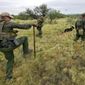 U.S. Border Patrol agents, aided by a dog and a Black Hawk helicopter, search for a group of migrants evading capture at the base of the Baboquivari Mountains, Thursday, Sept. 8, 2022, near Sasabe, Ariz. TThe desert region located in the Tucson sector just north of Mexico is one of the deadliest stretches along the international border with rugged desert mountains, uneven topography, washes and triple-digit temperatures in the summer months. Border Patrol agents performed 3,000 rescues in the sector in the past 12 months. (AP Photo/Matt York)