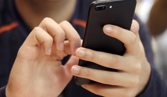 A person uses a smartphone in Chicago, Sept. 16, 2017. The European Union&#x27;s executive arm proposed new legislation Thursday, Sept. 15, 2022, that would force manufacturers to ensure that devices connected to the internet meet cybersecurity standards, making the 27-nation bloc less vulnerable to attacks. (AP Photo, File)