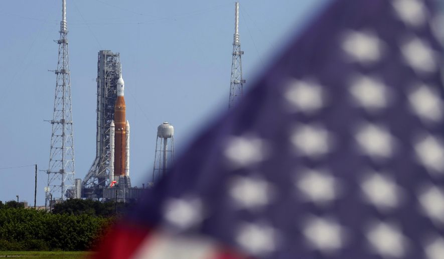 An American flag flies in the breeze as NASA&#x27;s new moon rocket sits on Launch Pad 39-B after being scrubbed at the Kennedy Space Center Sept. 3, 2022, in Cape Canaveral, Fla.  It’s not just rocket fuel propelling America’s first moonshot after a half-century lull. Rivalry with China’s space program is helping drive NASA’s effort to get back into space in a big way. That&#x27;s as both nations push to put people back on the moon and establish the first lunar bases. (AP Photo/Chris O&#x27;Meara, File)