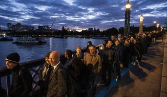 People stand in a queue to pay their respects to the late Queen Elizabeth II during the Lying-in State, outside Westminster Hall in London, Thursday, Sept. 15, 2022. The Queen will lie in state in Westminster Hall for four full days before her funeral on Monday Sept. 19. (AP Photo/Nariman El-Mofty)
