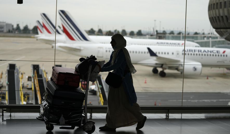 A traveler pulls her trolley Friday, Sept. 16, 2022 at Roissy Charles de Gaulle airport, north of Paris. Many domestic and some international flights were canceled in France Friday as air traffic controllers went on a national strike over pay and recruitment issues. French civil aviation authority DGAC warned that domestic traffic would be "severely disrupted" with many flights canceled and other experiencing long delays. Travelers have been advised to postpone their trip if possible. (AP Photo/Francois Mori)