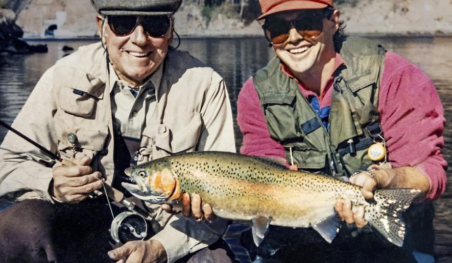 In this photo provided by Terry Gunn, Lehman Beardsley, left, and Gunn, who guides fishing trips, pose with a rainbow trout at Lees Ferry near Marble Canyon, Ariz., Nov 7, 1987. As Lake Powell reservoir just upstream declines, it sends warmer water with less oxygen into the river below the dam. Should that water reach 73 degrees, Gunn said his family&#39;s guide service may start calling off afternoon trips. (Courtesy of Terry Gunn via AP)