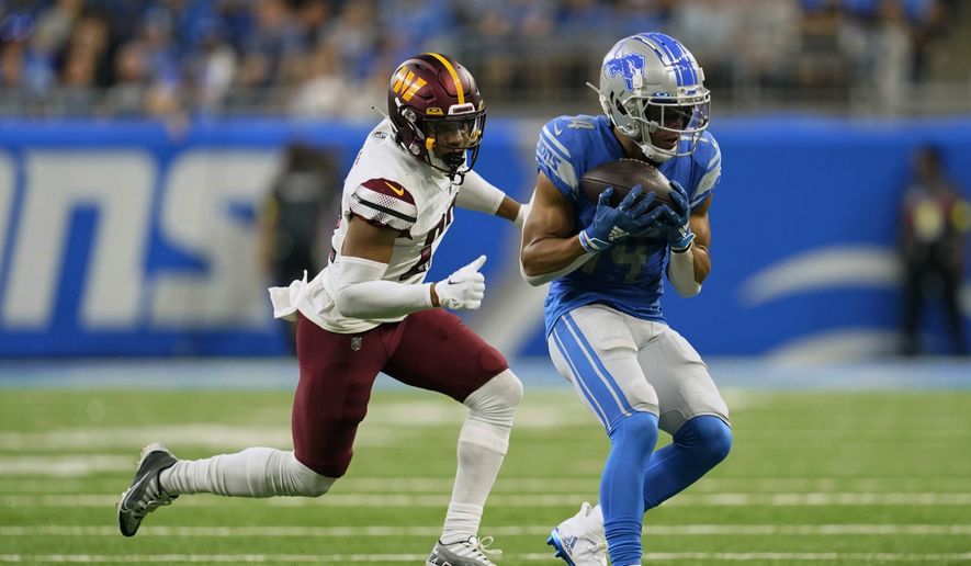 Detroit Lions wide receiver Amon-Ra St. Brown (14) makes a catch against Washington Commanders safety Darrick Forrest (22) during the second half of an NFL football game Sunday, Sept. 18, 2022, in Detroit. (AP Photo/Paul Sancya) **FILE**