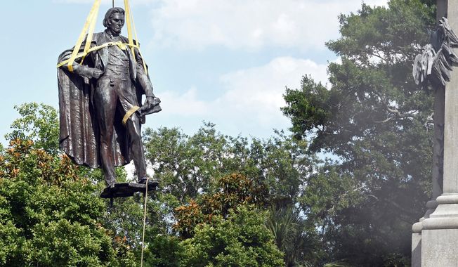 A statue of former U.S. Vice President and slavery advocate John C. Calhoun is raised by crews after its removal from a 100-foot-tall monument on Wednesday, June 24, 2020, in Charleston, S.C. Lawsuits filed to stop the removal of memorials to Confederate leaders and the pro-slavery congressman in a South Carolina city have been dropped. The Post and Courier reports that the American Heritage Association helped fund one of the lawsuits. It had been filed by descendants of John C. Calhoun, a former congressman and vice president who died before the Civil War. (AP Photo/Meg Kinnard, File)