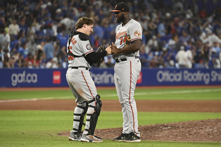 Baltimore Orioles closing pitcher Felix Bautista, right, and catcher Adley Rutschman celebrate their victory over the Toronto Blue Jays in baseball game in Toronto, Sunday, Sept. 18, 2022. (Jon Blacker/The Canadian Press via AP)