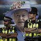 Police officers are backdropped by a photograph of Queen Elizabeth II in London, Friday, Sept.16, 2022. The Queen will lie in state in Westminster Hall for four full days before her funeral on Monday Sept. 19.(AP Photo/Vadim Ghirda)