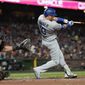 Los Angeles Dodgers designated hitter Justin Turner, right, hits an RBI single in front of San Francisco Giants catcher Joey Bart during the fourth inning of a baseball game in San Francisco, Saturday, Sept. 17, 2022. (AP Photo/Jeff Chiu)
