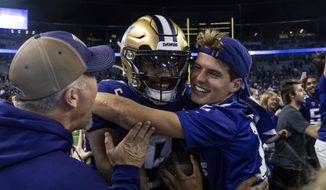 Fans celebrate with Washington quarterback Michael Penix Jr., center, after an NCAA college football game against Michigan State, Saturday, Sept. 17, 2022, in Seattle.  (AP Photo/Stephen Brashear) **FILE**