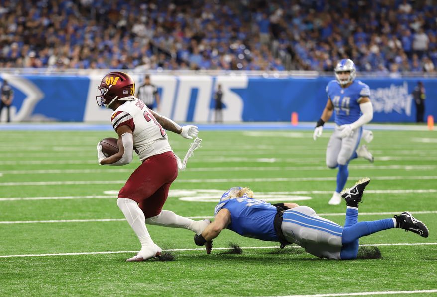 Washington Commanders&#39; RB Antonio Gibson (24) slips through the grip of the Detroit Lions defenseman at the Washington Commanders vs the Detroit Lions at Ford Field in Detroit Michigan on September 18th 2022 (Photo: Alyssa Howell)