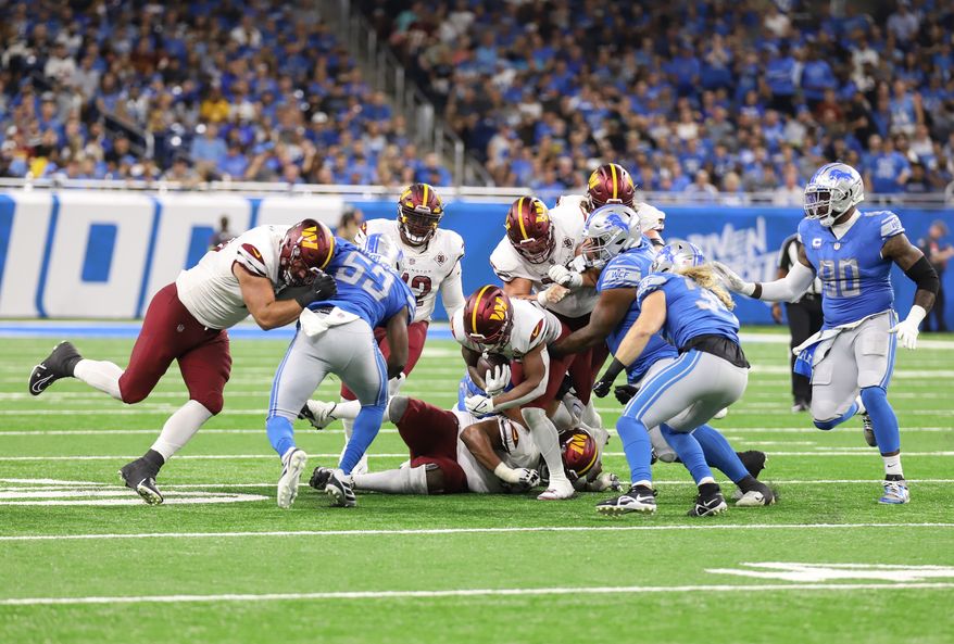 Washington Commanders&#x27; Offense makes a running play but is stopped by the Lions defense at the Washington Commanders vs the Detroit Lions at Ford Field in Detroit Michigan on September 18th 2022 (Photo: Alyssa Howell)