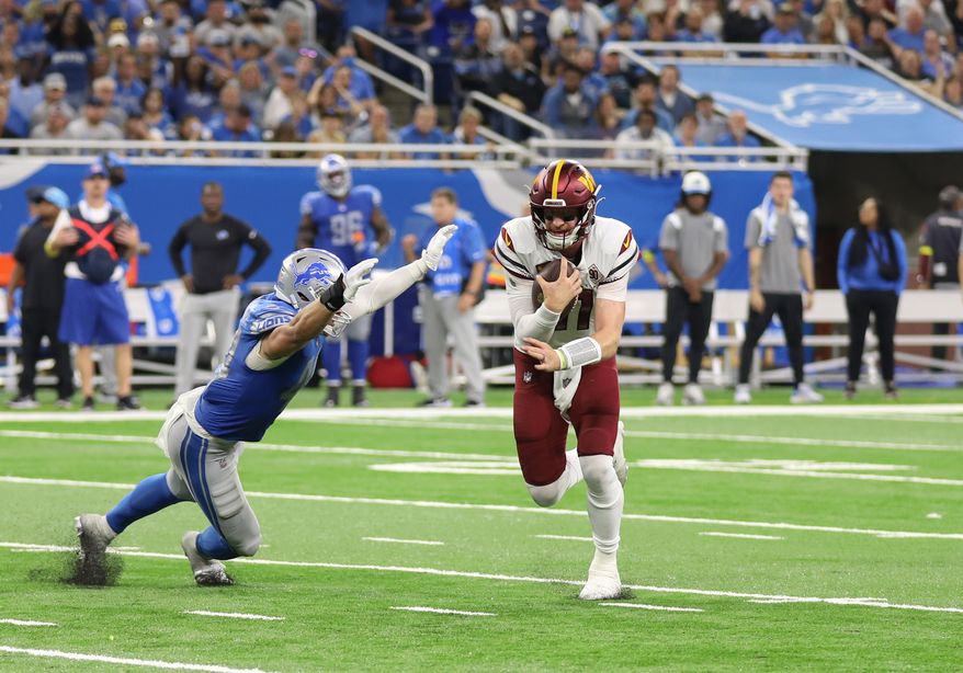 Washington Commanders&#39; QB Carson Wentz (11) avoids the tackle and runs the ball at the Washington Commanders vs the Detroit Lions at Ford Field in Detroit Michigan on September 18th 2022 (Photo: Alyssa Howell)