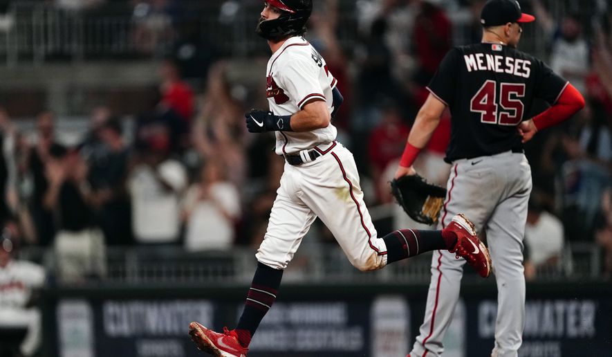 Atlanta Braves&#39; Dansby Swanson (7) runs past Washington Nationals first baseman Joey Meneses (45) after hitting a solo home run during the eighth inning of a baseball game Tuesday, Sept. 20, 2022, in Atlanta. (AP Photo/John Bazemore)