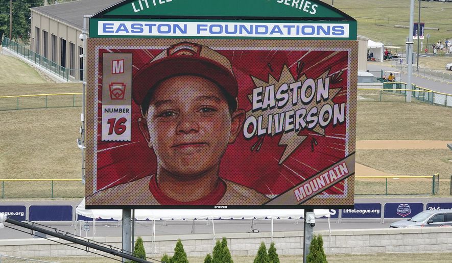 An image of Mountain Region Champion Little League team member Easton Oliverson is displayed on the scoreboard at Volunteer Stadium during the opening ceremony of the 2022 Little League World Series baseball tournament in South Williamsport, Pa., on Aug 17, 2022. The family Easton Oliverson, who suffered a serious head injury after falling from a top bunk bed during last month&#39;s Little League World Series in Pennsylvania, has sued the league and a furniture company. Oliverson, 12, suffered a skull fracture and bleeding on the brain in the Aug. 15 fall at a players dormitory in Williamsport, according to the family&#39;s social media posts. He has since had three brain operations and has battled a staph infection and, more recently, seizures, their lawyer said Tuesday. (AP Photo/Gene J. Puskar, File) **FILE**
