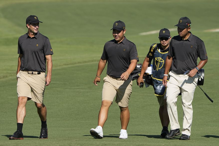 Adam Scott, of Australia, Tom Kim and Hideki Matsuyama, of Japan, walk up the fifth fairway during practice for the Presidents Cup golf tournament at the Quail Hollow Club, Tuesday, Sept. 20, 2022, in Charlotte, N.C. (AP Photo/Chris Carlson)