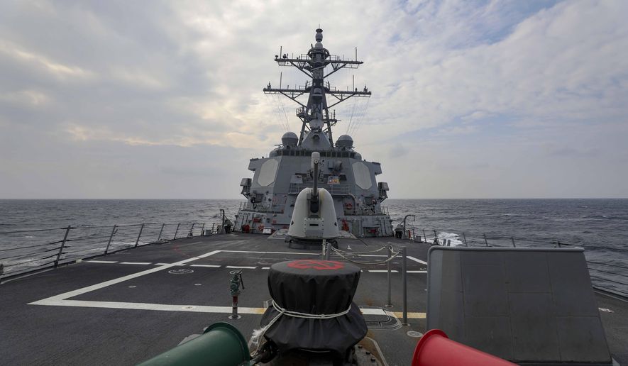 In this photo provided by U.S. Navy, The guided-missile destroyer USS Higgins (DDG 76) conducts a routine Taiwan Strait transit Sept. 20, 2022. China toned down its rhetoric on Taiwan on Wednesday, Sept. 21, saying it is inevitable that the self-governing island comes under its control but that it would promote efforts to achieve that peacefully. The comments came one day after the U.S. and Canadian navies sailed through the strait between China and Taiwan. (Mass Communication Specialist 1st Class Donavan K. Patubo/U.S.Navy via AP)