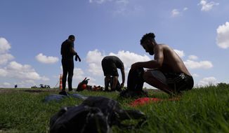 Migrants gather their personal items as they wait to be processed by the Border Patrol after illegally crossing the Rio Grande River from Mexico into the United States at Eagle Pass, Texas, Friday, Aug. 26, 2022. Venezuelans have surpassed Guatemalans and Hondurans to become the second-largest nationality stopped at the U.S. border in August 2022 after Mexicans. (AP Photo/Eric Gay, File)