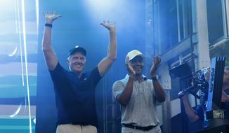 LIV Golf CEO Greg Norman, left, and LIV Golf managing director Majed Al Sorour cheer from the stage before the trophy presentation at the LIV Golf Invitational-Boston tournament, Sunday, Sept. 4, 2022, in Bolton, Mass. (AP Photo/Mary Schwalm) **FILE**