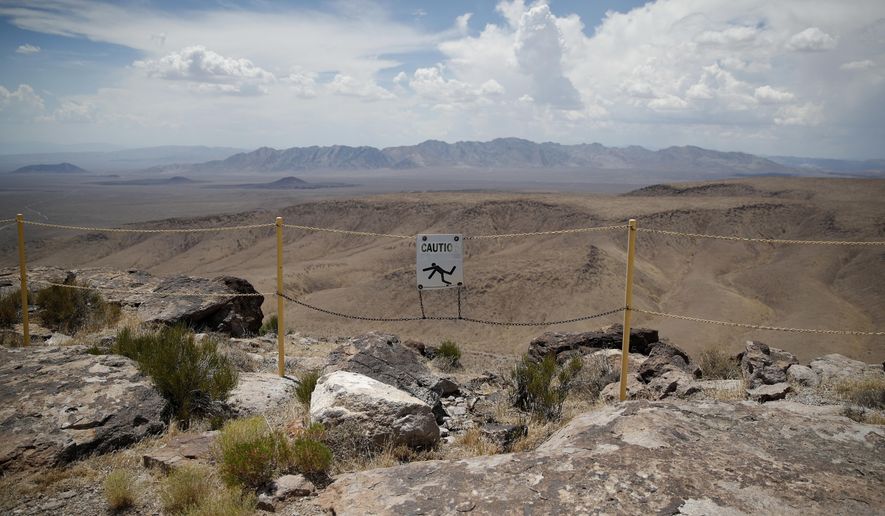 In this July 14, 2018, photo, a sign warns of a falling danger on the crest of Yucca Mountain during a congressional tour near Mercury, Nev. Nevada is asking the federal Nuclear Regulatory Commission to restart its look at licensing the mothballed Yucca Mountain national radioactive waste repository, with the expectation that will finally end four decades of debate and kill it. (AP Photo/John Locher) **FILE**