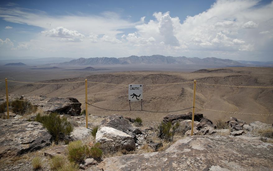 In this July 14, 2018, photo, a sign warns of a falling danger on the crest of Yucca Mountain during a congressional tour near Mercury, Nev. Nevada is asking the federal Nuclear Regulatory Commission to restart its look at licensing the mothballed Yucca Mountain national radioactive waste repository, with the expectation that will finally end four decades of debate and kill it. (AP Photo/John Locher) **FILE**