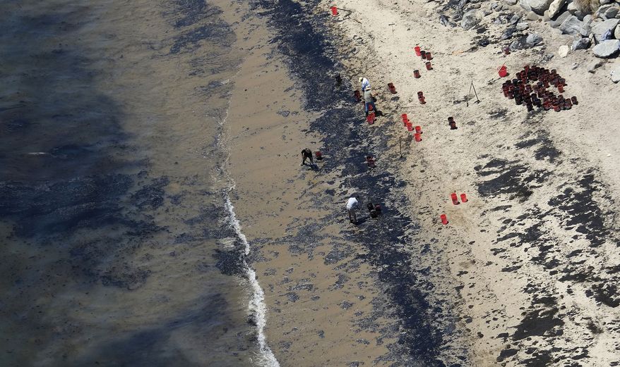 Volunteers fill buckets with oil near Refugio State Beach after an oil spill north of Goleta, Calif., May 20, 2015. A judge has approved a $230 million lawsuit settlement by the owners of a pipeline that spilled more than 140,000 gallons of crude oil into the ocean off California in 2015. (AP Photo/Michael A. Mariant, File)