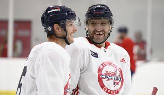 Washington Capitals left wing Alex Ovechkin, of Russia, right, and center Nic Dowd, left, laugh at an NHL hockey training camp, Thursday, Sept. 22, 2022, in Arlington, Va. (AP Photo/Nick Wass)