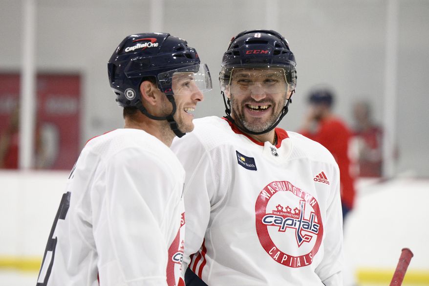 Washington Capitals left wing Alex Ovechkin, of Russia, right, and center Nic Dowd, left, laugh at an NHL hockey training camp, Thursday, Sept. 22, 2022, in Arlington, Va. (AP Photo/Nick Wass)