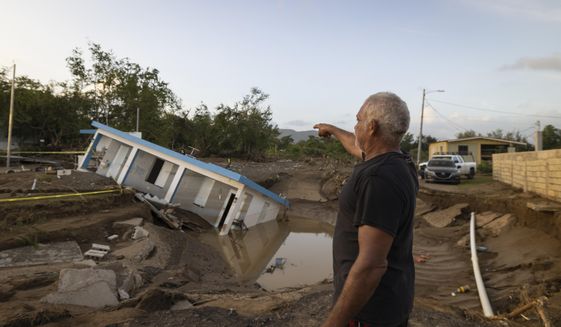 A man points to a home that was collapsed by Hurricane Fiona at Villa Esperanza in Salinas, Puerto Rico, Wednesday, Sept. 21, 2022. (AP Photo/Alejandro Granadillo)