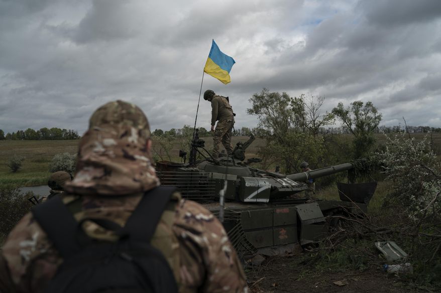 A Ukrainian national guard serviceman stands atop a destroyed Russian tank in an area near the border with Russia, in Kharkiv region, Ukraine, Sept. 19, 2022. A swift Ukrainian counteroffensive earlier this month that forced Russian troops to retreat from broad swaths of the northeastern Kharkiv region has forced the Kremlin to rush absorbing Russia-held areas in Ukraine&#39;s east and south. (AP Photo/Leo Correa, File)