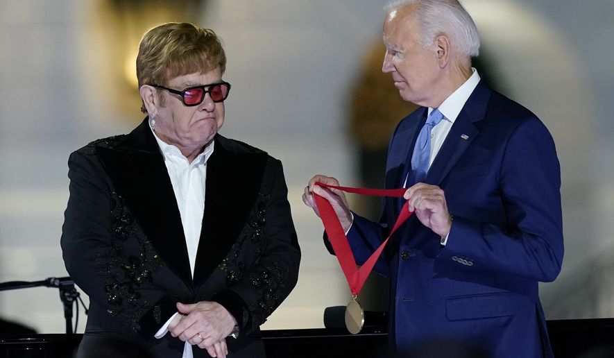 President Joe Biden presents Elton John with the National Humanities Medal after a concert on the South Lawn of the White House in Washington, Friday, Sept. 23, 2022. (AP Photo/Susan Walsh)