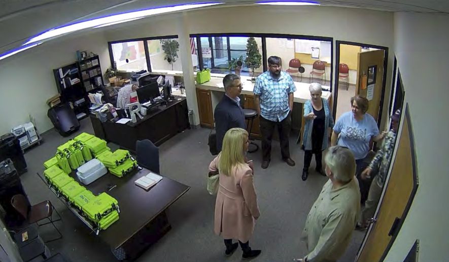 This Jan. 7, 2021, image taken from Coffee County, Ga., security video, appears to show Cathy Latham (center, long turquoise top), introducing members of a computer forensic team to local election officials. Latham was the county Republican Party chair at the time. The computer forensics team was at the county elections office in Douglas, Ga., to make copies of voting equipment in an effort that documents show was arranged by Sidney Powell and others allied with then-President Donald Trump. (Coffee County, Georgia via AP)