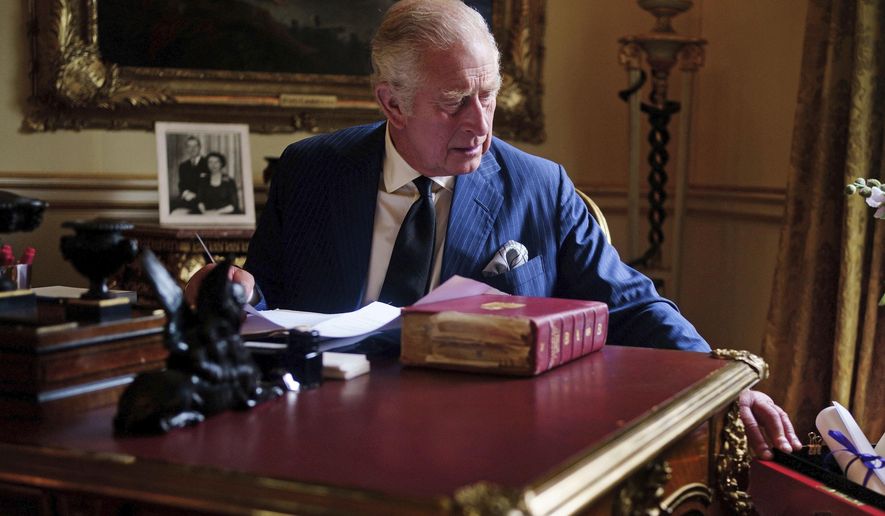 In this photo Sept. 11, 2022, taken Britain&#x27;s King Charles III carries out official government duties from his red box in the Eighteenth Century Room at Buckingham Palace, London. (Victoria Jones/PA via AP)