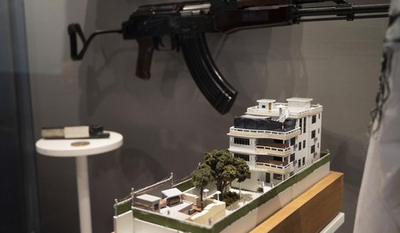 A model of the house where a precision counterterrorism operation killed al-Qaida&#39;s leader Ayman al-Zawahri is displayed below a rifle used by Michael Spann, the first American killed in Afghanistan, in the refurbished museum at the Central Intelligence Agency headquarters building in Langley, Va., on Saturday, Sept. 24, 2022. (AP Photo/Kevin Wolf)