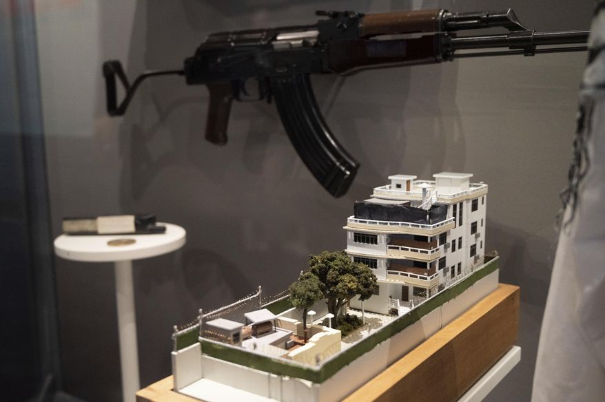 A model of the house where a precision counterterrorism operation killed al-Qaida&#x27;s leader Ayman al-Zawahri is displayed below a rifle used by Michael Spann, the first American killed in Afghanistan, in the refurbished museum at the Central Intelligence Agency headquarters building in Langley, Va., on Saturday, Sept. 24, 2022. (AP Photo/Kevin Wolf)