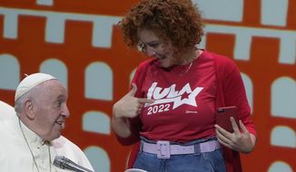 A woman shows to Pope Francis a t-shirt supporting former Brazilian President Luiz Inacio Lula da Silva during the &#39;Economy of Francesco&#39; meetings with young entrepreneurs for a more inclusive and human economy, in Assisi, Saturday, Sept. 24, 2022. (AP Photo/Gregorio Borgia)
