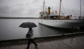 A pedestrian shields themselves with an umbrella while walking along the Halifax waterfront as rain falls ahead of Hurricane Fiona making landfall in Halifax, Friday, Sept. 23, 2022. (Darren Calabrese /The Canadian Press via AP)