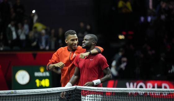 Team World&#39;s Felix Auger-Aliassime, left, hugs teammate Frances Tiafoe after the latter won the singles tennis match against Team Europe&#39;s Stefanos Tsitsipas on the third day of the Laver Cup tennis tournament at the O2 arena in London, Sunday, Sept. 25, 2022. (AP Photo/Kin Cheung)