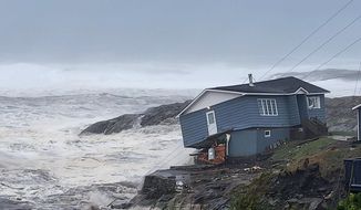 In this photo provided by Wreckhouse Press a home fights against high winds caused by post Tropical Storm Fiona in Port aux Basques, Newfoundland and Labrador, Saturday, Sept. 24, 2022. The home has since been lost at sea. (Rene Roy/Wreckhouse Press via AP)