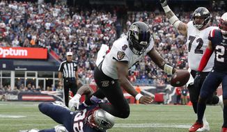 Baltimore Ravens quarterback Lamar Jackson (8) scores a touchdown as New England Patriots safety Devin McCourty (32), below left, tries to defend in the second half of an NFL football game, Sunday, Sept. 25, 2022, in Foxborough, Mass. (AP Photo/Michael Dwyer) ** FILE**