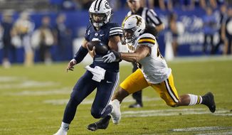 BYU quarterback Jaren Hall carries the ball past Wyoming linebacker Shae Suiaunoa during the first half of an NCAA college football game Saturday, Sept. 24, 2022, in Provo, Utah. (AP Photo/Rick Bowmer)