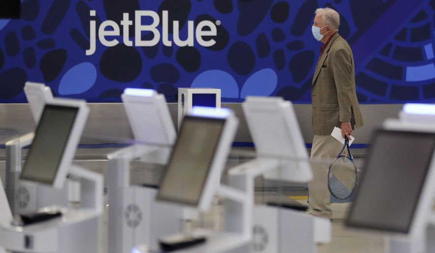 FILE - A traveler walks through the JetBlue terminal at Logan Airport in Boston, Friday, May 29, 2020. The government is getting its day in court to try to block a partnership between American Airlines and JetBlue. A trial is scheduled to start Tuesday, Sept. 26, 2022 in the Justice Department&#39;s antitrust lawsuit against the airlines. (AP Photo/Charles Krupa, File)