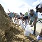 Johnny Ford, right, and his wife Jerria Ford fill free sand bags at an Orange County park in preparation for the arrival of Hurricane Ian, Monday, Sept. 26, 2022, in Orlando, Fla. (AP Photo/Phelan M. Ebenhack)