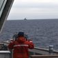 In this photo provided by the U.S. Coast Guard, a Coast Guard Cutter Kimball crew-member observes a foreign vessel in the Bering Sea, Monday, Sept. 19, 2022. The U.S. Coast Guard cutter on routine patrol in the Bering Sea came across the guided missile cruiser from the People&#39;s Republic of China, officials said Monday, Sept. 26.  (U.S. Coast Guard District 17 via AP)